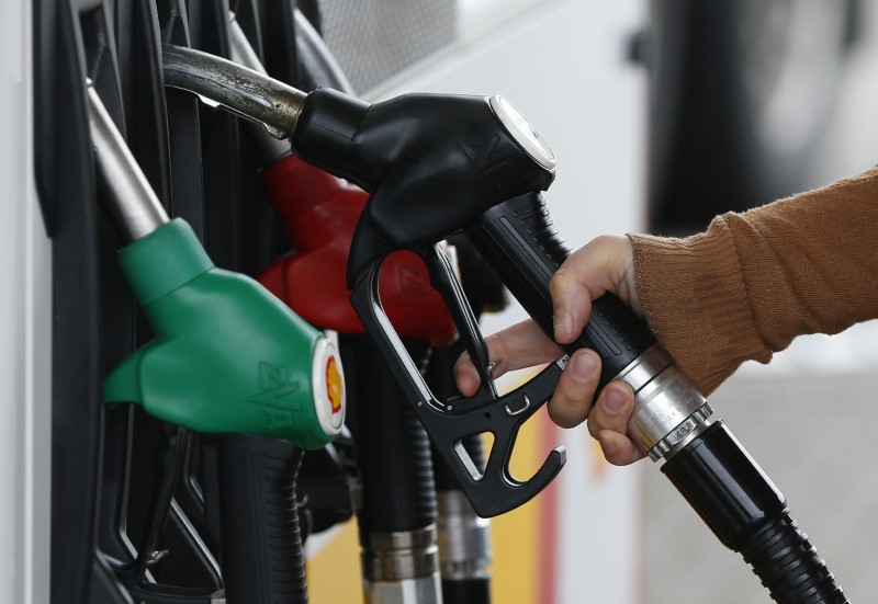 © Reuters. A customer prepares to fill the tank of her car at a fuel station in Sint Pieters Leeuw