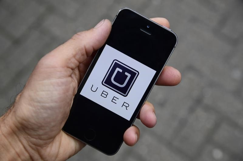 © Reuters. A photo illustration shows the Uber app logo displayed on a mobile telephone, as it is held up for a posed photograph in central London