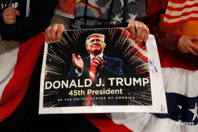 © Reuters. Сторонник президента США Дональда Трампа держит в руках плакат с его изображением в Де-Мойне, Айова