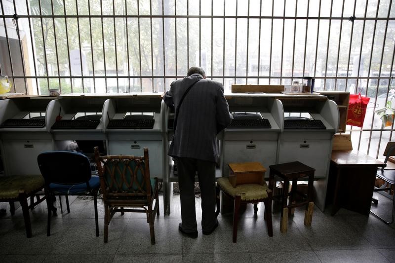 © Reuters. An investor looks at a screen showing stock information at a brokerage house in Shanghai