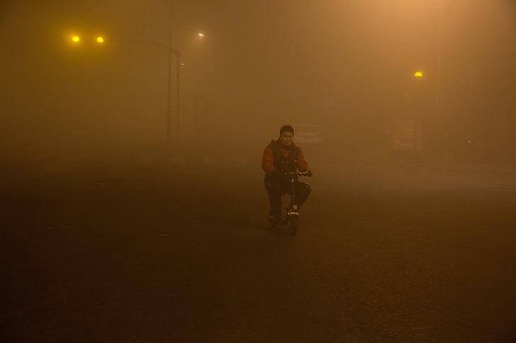 © Reuters. الضباب الدخاني يغلف مدنا في شمال الصين لليوم الرابع