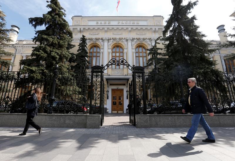 © Reuters. People walk past the Central Bank headquarters in Moscow