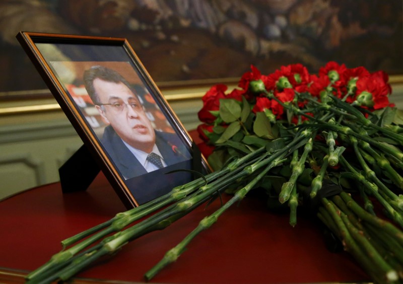 © Reuters. Flowers are placed near a portrait of murdered Russian ambassador to Turkey Karlov during a meeting of Russian Foreign Minister Lavrov with his Turkish counterpart Cavusoglu in Moscow