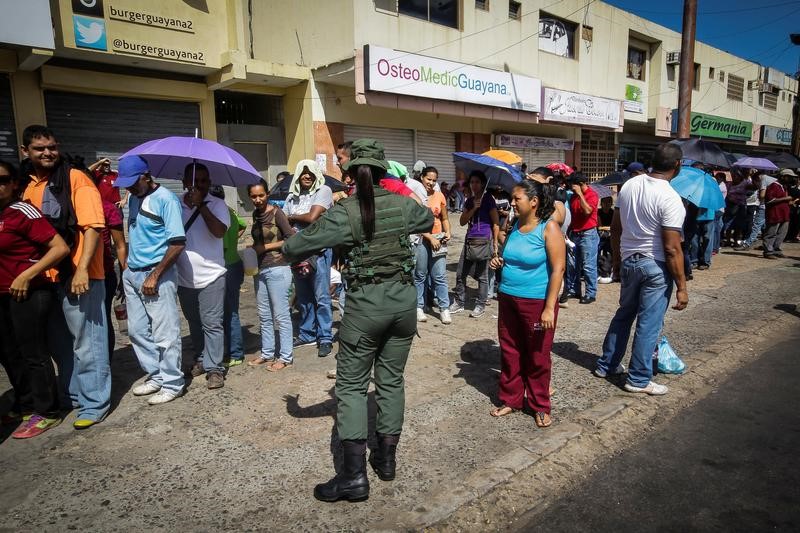 © Reuters. Militar controla fila em Ciudad Bolívar, na Venezuela