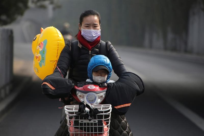 © Reuters. Mulher e criança usam máscaras por conta da poluição em Pequim