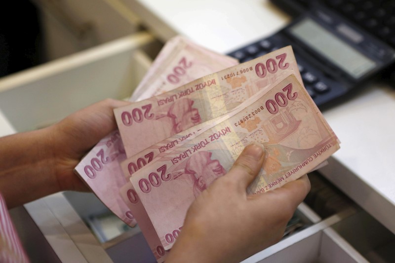 © Reuters. A money changer counts Turkish lira bills at an currency exchange office in central Istanbul, file