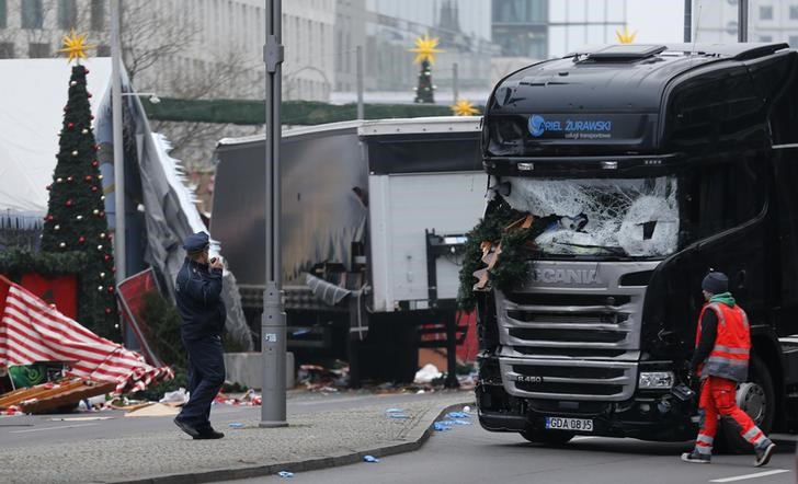 © Reuters. Policial ao lado de caminhão que atropelou multidão em mercado natalino de Berlim, matando 12 pessoas