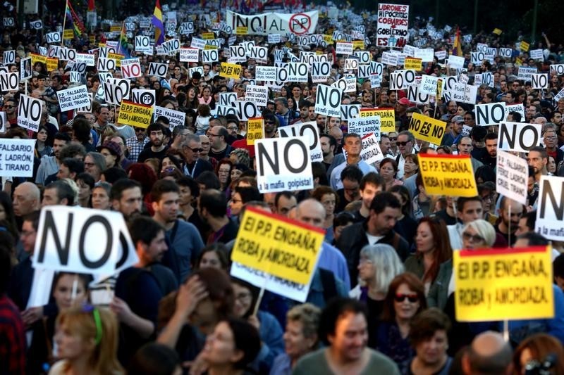 © Reuters. Demonstrators attend a protest against the investiture of acting Prime Minister and Popular Party leader Mariano Rajoy in Madrid