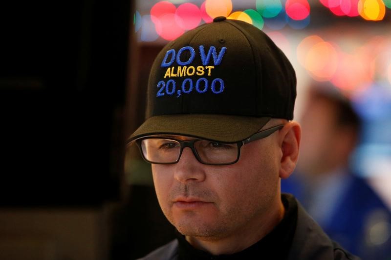 © Reuters. Specialist trader Mario Picone wears a "DOW Almost 20,000" cap as he works at his post on the floor the New York Stock Exchange in  New York City