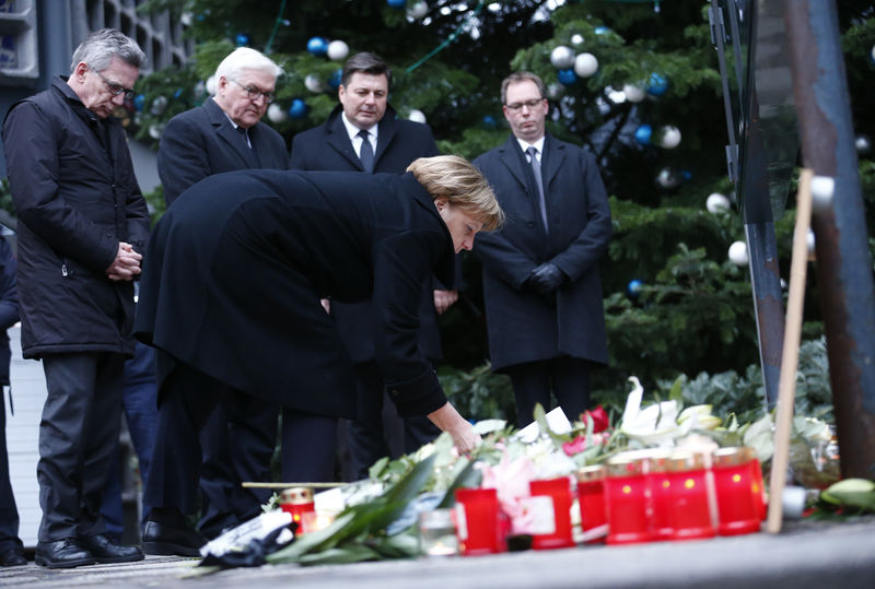 © Reuters. Merkel coloca flores em local de ataque em Berlim