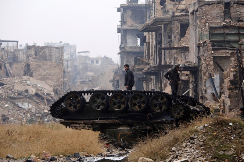 © Reuters. FILE PHOTO: Forces loyal to Syria's President Bashar al-Assad stand atop a damaged tank near Umayyad mosque, in the government-controlled area of Aleppo, during a media tour, Syria