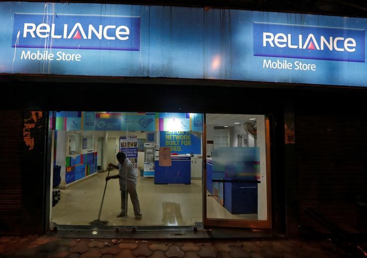 © Reuters. A worker cleans a mobile store of Reliance Communications Ltd, controlled by billionaire Anil Ambani, in Kolkata