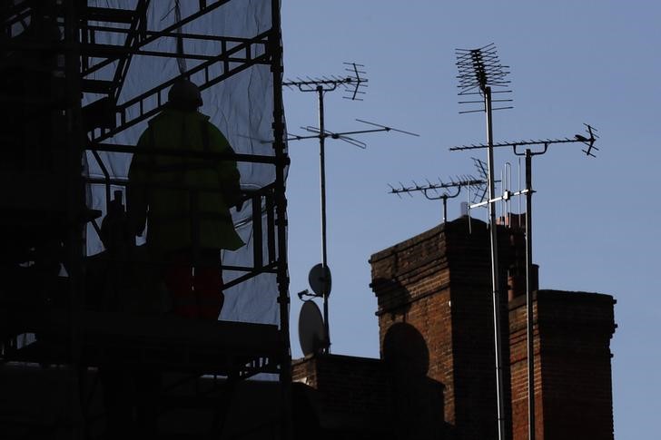 © Reuters. A worker uses a stair at a construction site in central London