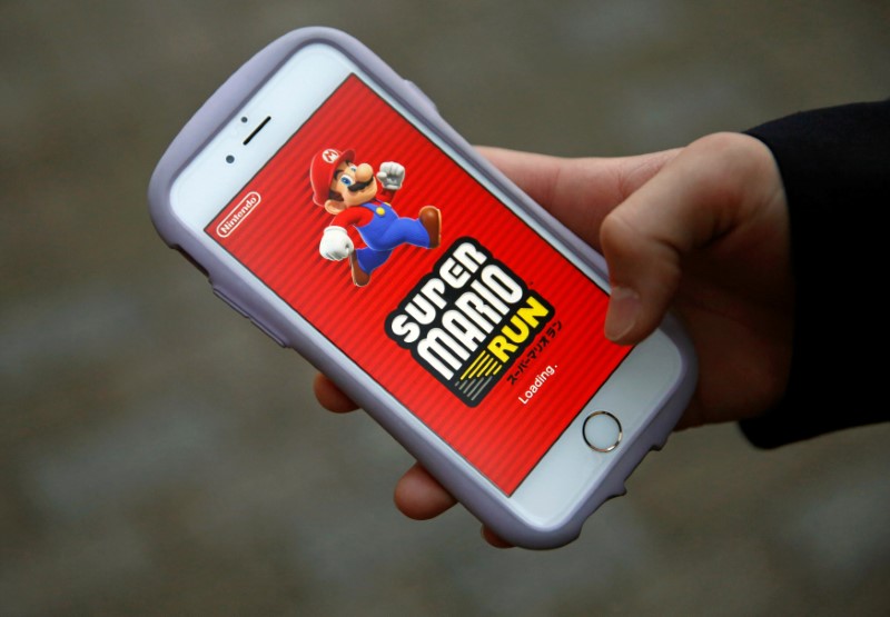 © Reuters. Takuya Nishya shows Nintendo's "Super Mario Run" game on his smartphone by the request of a photographer in Tokyo
