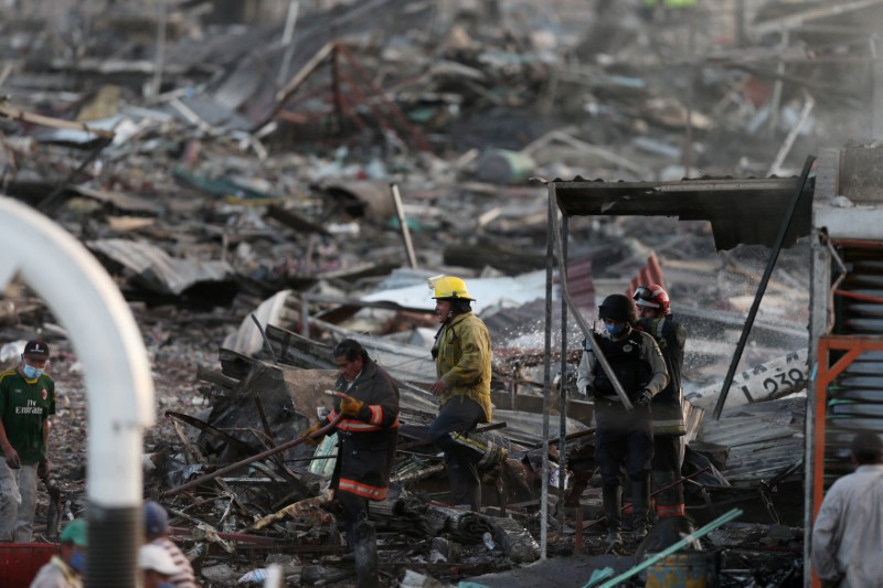 © Reuters. Bombeiros em meio a destroços após explosão no mercado San Pablito, na cidade mexicana de Tultepec