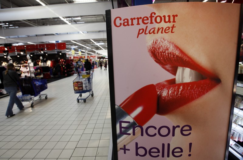 © Reuters. Shoppers walk past the beauty section at Carrefour Planet supermarket in Nice Lingostiere