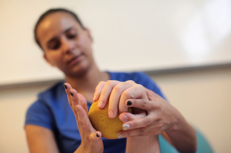 © Reuters. Adapted Physical Education (APE) teacher Jinelynet Matos works with a patient at the Abriendo Puertas al Futuro (Opening Doors to the Future) day center in Bayamon