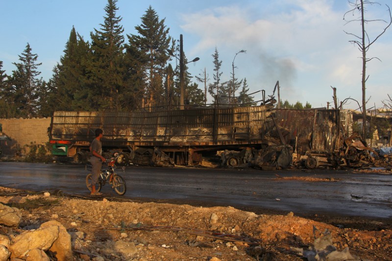 © Reuters. A boy inspects a damaged aid truck after an airstrike on the rebel held Urm al-Kubra town