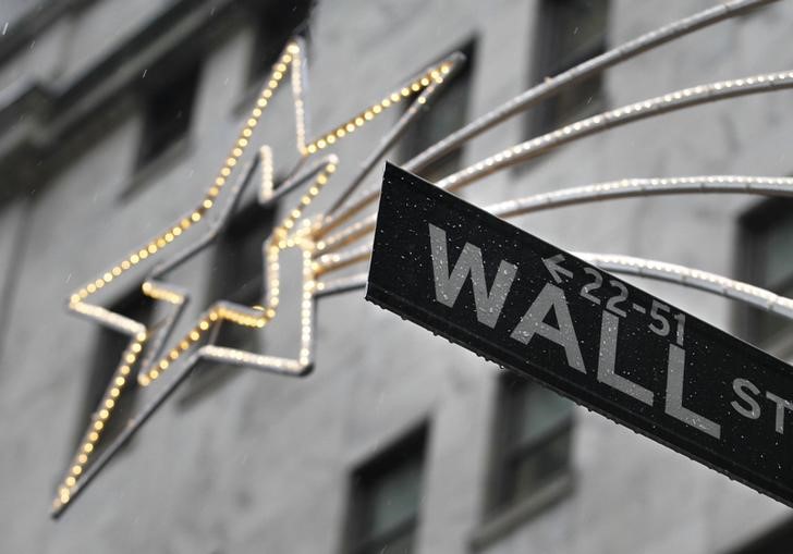 © Reuters. A holiday decoration is seen over Wall St. sign outside the New York Stock Exchange