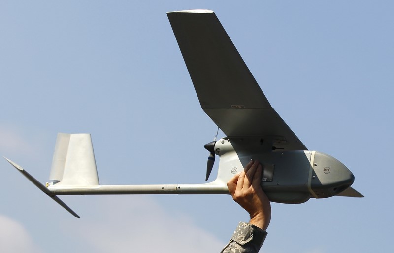© Reuters. US soldier poses with 'Raven' drone during presentation by UAS at US military base in Vilseck-Grafenwoehr