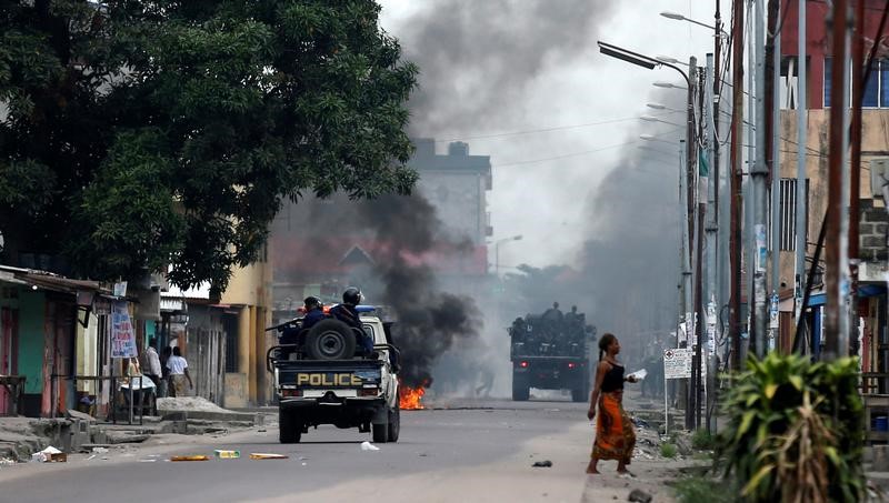 © Reuters. Policiais passam por barricada durante manifestações contra o presidente congolês, Joseph Kabila, em Kinshasa