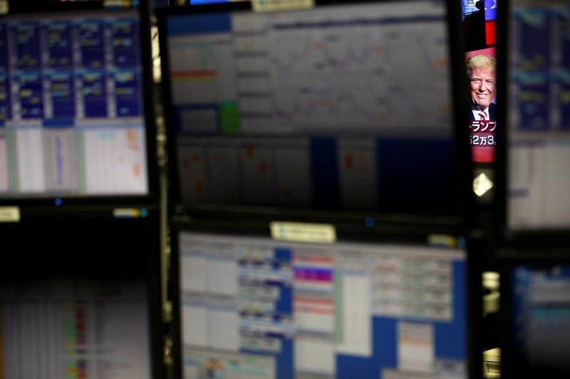 © Reuters. U.S. Republican presidential nominee Donald Trump is seen between monitors on TV news at a foreign exchange trading company in Tokyo,