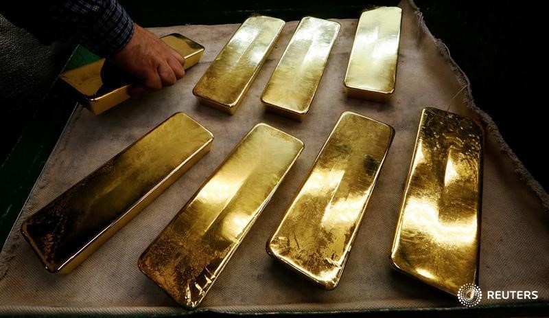 © Reuters. Сотрудник завода Красцветмет раскладывает слитки золота