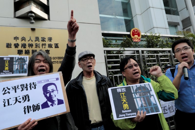 © Reuters. Pro-democracy demonstrators hold up portraits of Chinese disbarred lawyer Jiang Tianyong, demanding his release, during a demonstration outside the Chinese liaison office in Hong Kong