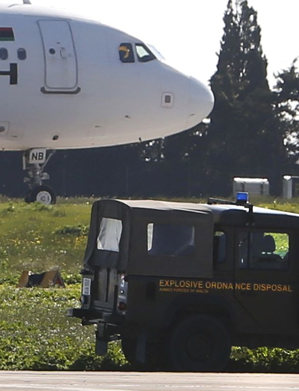 © Reuters. Veículo militar ao lado de avião sequestrado da Afriqiyah Airways em aeroporto em Malta