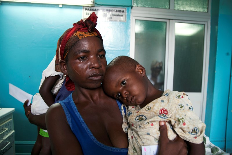 © Reuters. Mãe leva filha com febre amarela para hospital em Luanda