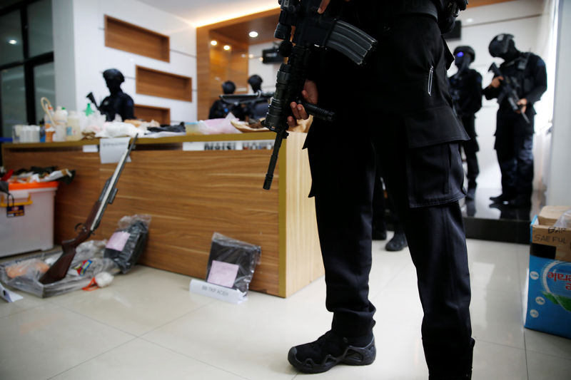 © Reuters. Indonesian anti-terror police from Detachment 88 stand guard near explosive materials and other evidence confiscated in raids on suspected militants, in Jakarta