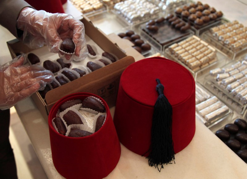 © Reuters. FILE PHOTO - Employee puts dates in a Tarbush special gifts during the month of Ramadan at Ghraoui chocolate shop in Damascus