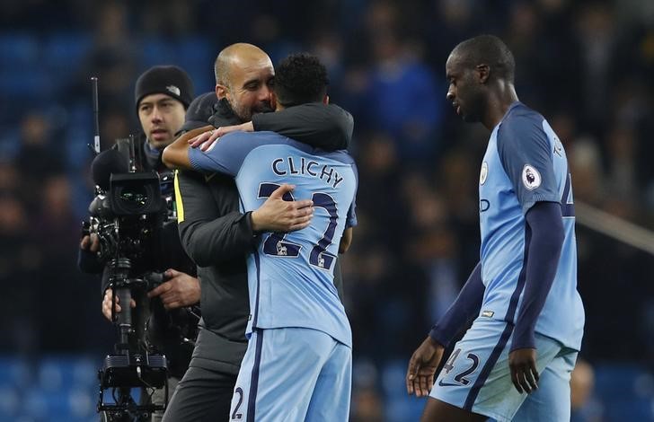 © Reuters. Manchester City manager Pep Guardiola celebrates with Gael Clichy at the end of the match