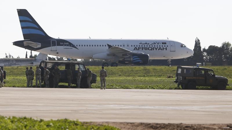 © Reuters. Военные у самолета Airbus A320 компании Afriqiyah Airways в аэропорту Мальты