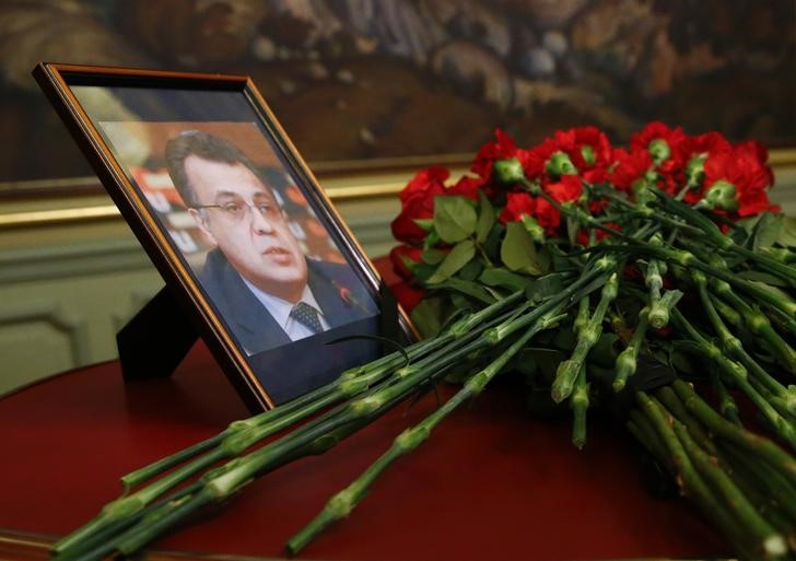 © Reuters. Гвоздики у фотографии убитого российского посла в Турции Андрея Карлова