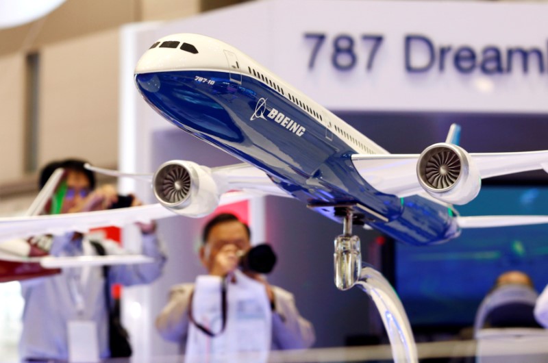 © Reuters. Visitors take pictures of a model of Boeing's 787 Dreamliner during Japan Aerospace 2016 air show in Tokyo