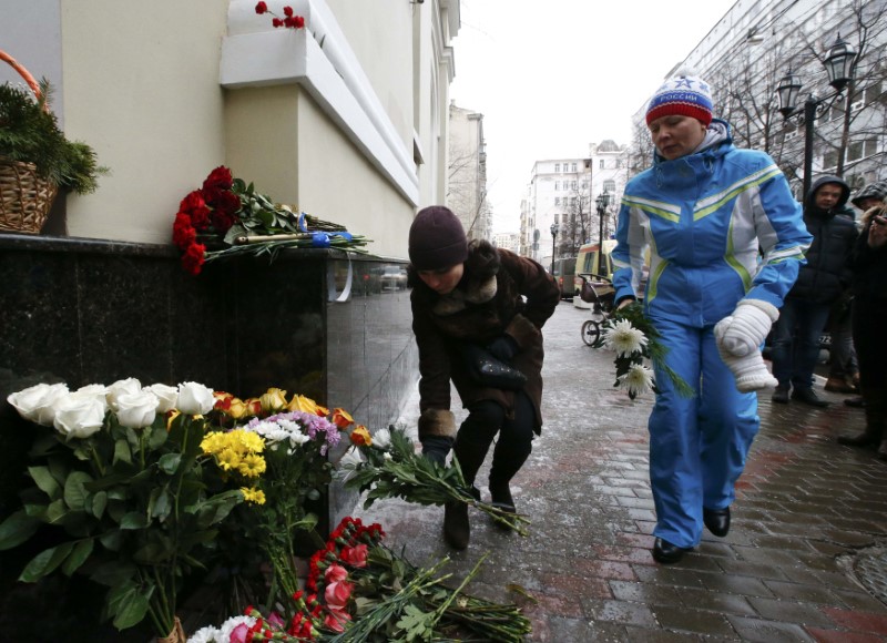 © Reuters. People lay flowers in memory of passengers and crew members of Russian military Tu-154 plane crashed into Black Sea, outside headquarters of Red Army Choir in Moscow