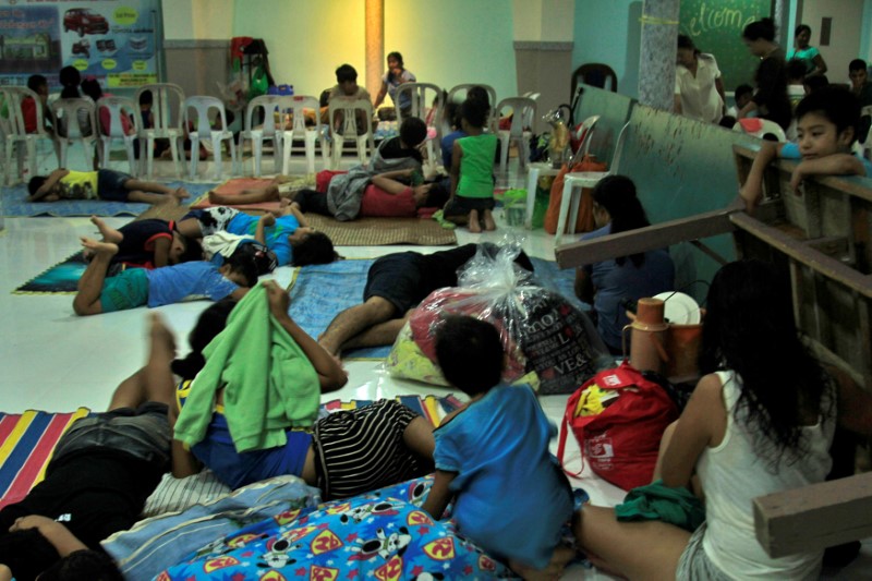 © Reuters. Residentes celebran Navidad en un centro de evacuación por el paso del tifón Nock-ten, Legazpi