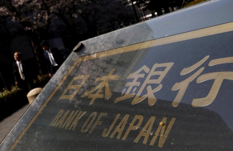 © Reuters. People walk along a street in front of the Bank of Japan headquarters in Tokyo