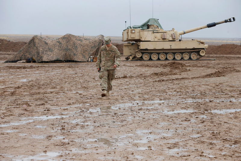 © Reuters. U.S. soldier walks in front of a tank at an army base in Karamless town, east of Mosul