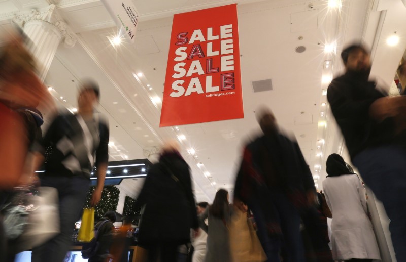 © Reuters. Shopper pass a sale sign during the Boxing Day sales at a Selfridges store in London, Britain