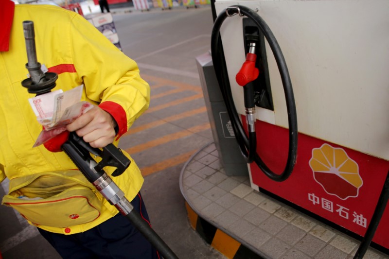 © Reuters. A gas station attendant pumps fuel into a customer's car at PetroChina's petrol station in Beijing