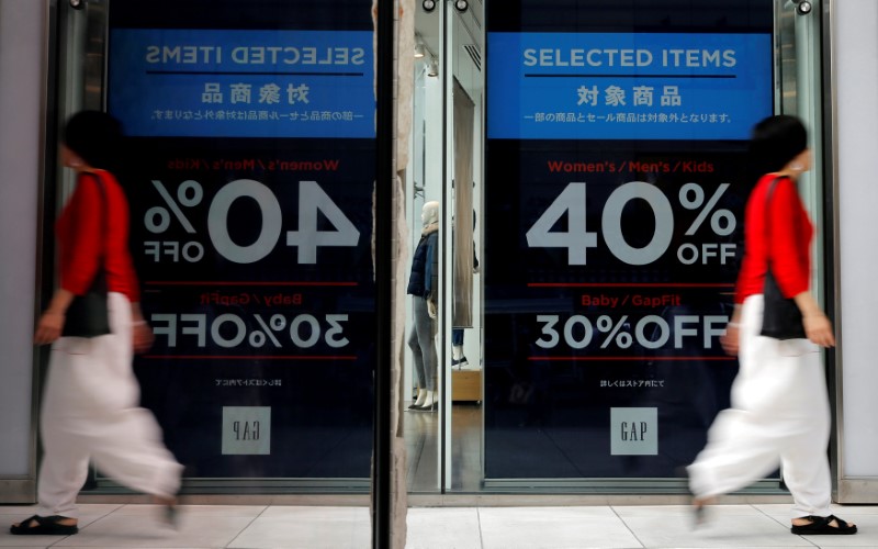 © Reuters. FILE PHOTO: Woman walks outside a fashion boutique in a shopping district in Tokyo