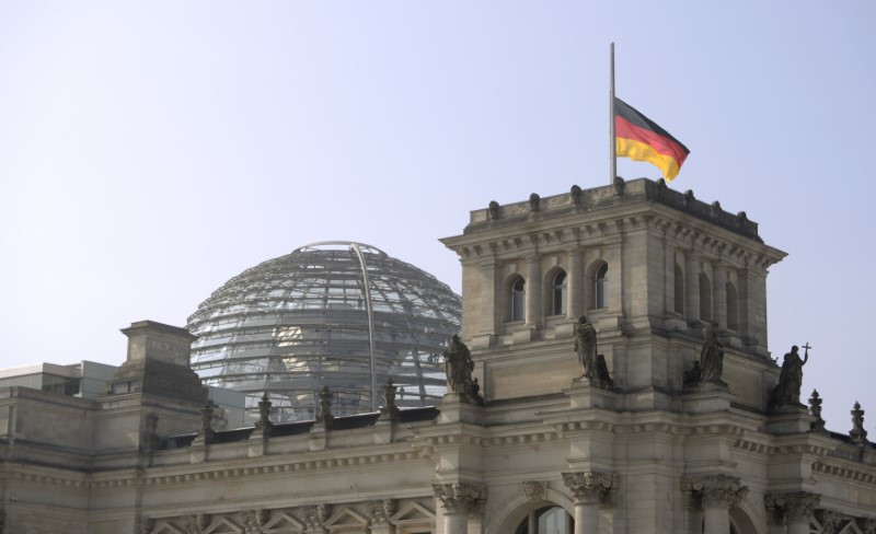 © Reuters. German flag flutters half-mast on top of the Reichstag building, the seat of the German lower house of parliament Bundestag in Berlin