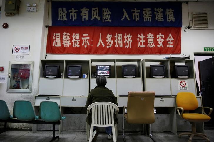 © Reuters. An investor looks at a screen showing stock information at a brokerage house in Shanghai