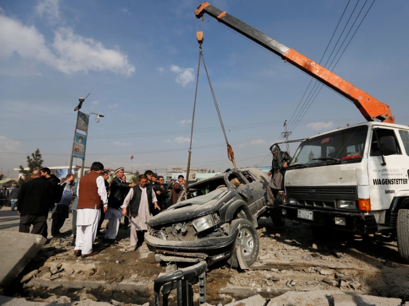 © Reuters. Afghans remove a damaged vehicle at the site of a blast in Kabul, Afghanistan