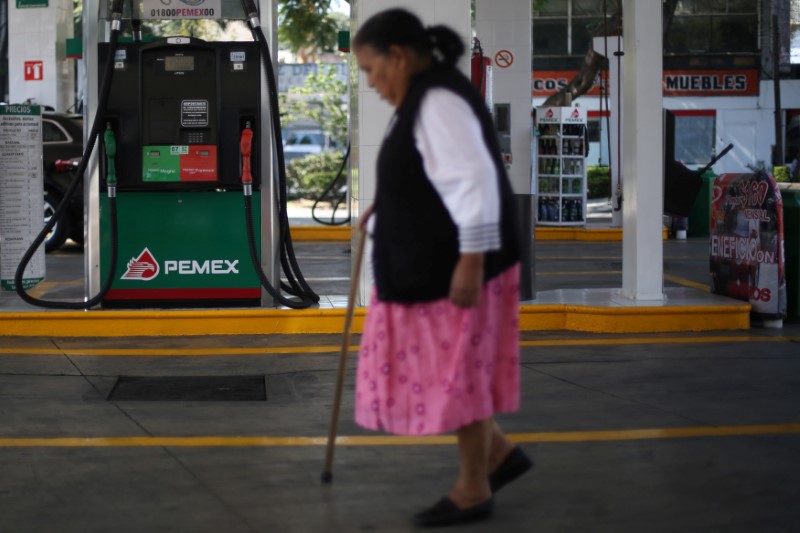 © Reuters. A woman walks next to fuel pumps at Pemex gas station in Mexico City