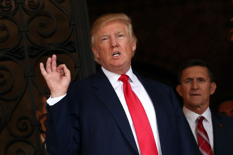 © Reuters. U.S. President-elect Donald Trump talks to members of the media as Retired U.S. Army Lieutenant General Michael Flynn stands next to him at Mar-a-Lago estate in Palm Beach, Florida