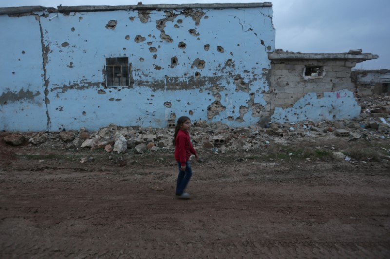 © Reuters. A girl walks near a damaged house in al-Rai town, northern Aleppo province