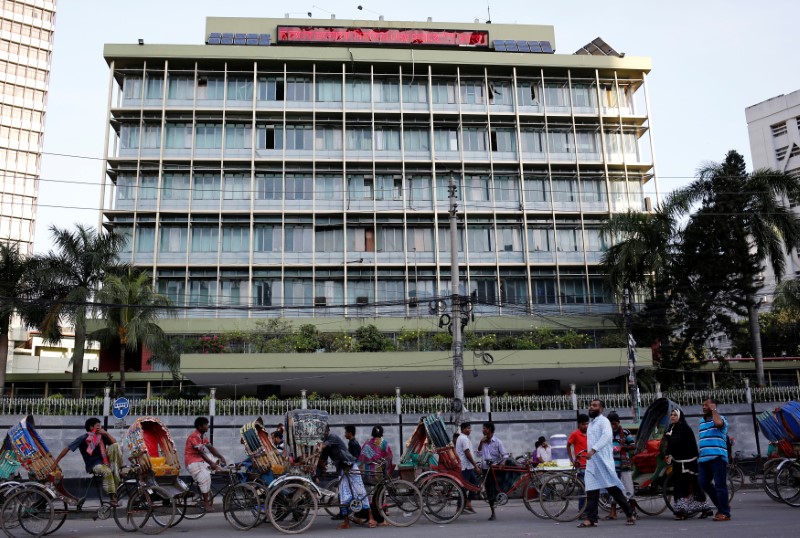 © Reuters. Commuters walk in front of the Bangladesh central bank building in Dhaka